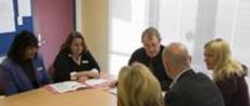 This is an image of professionals talking around the table. 